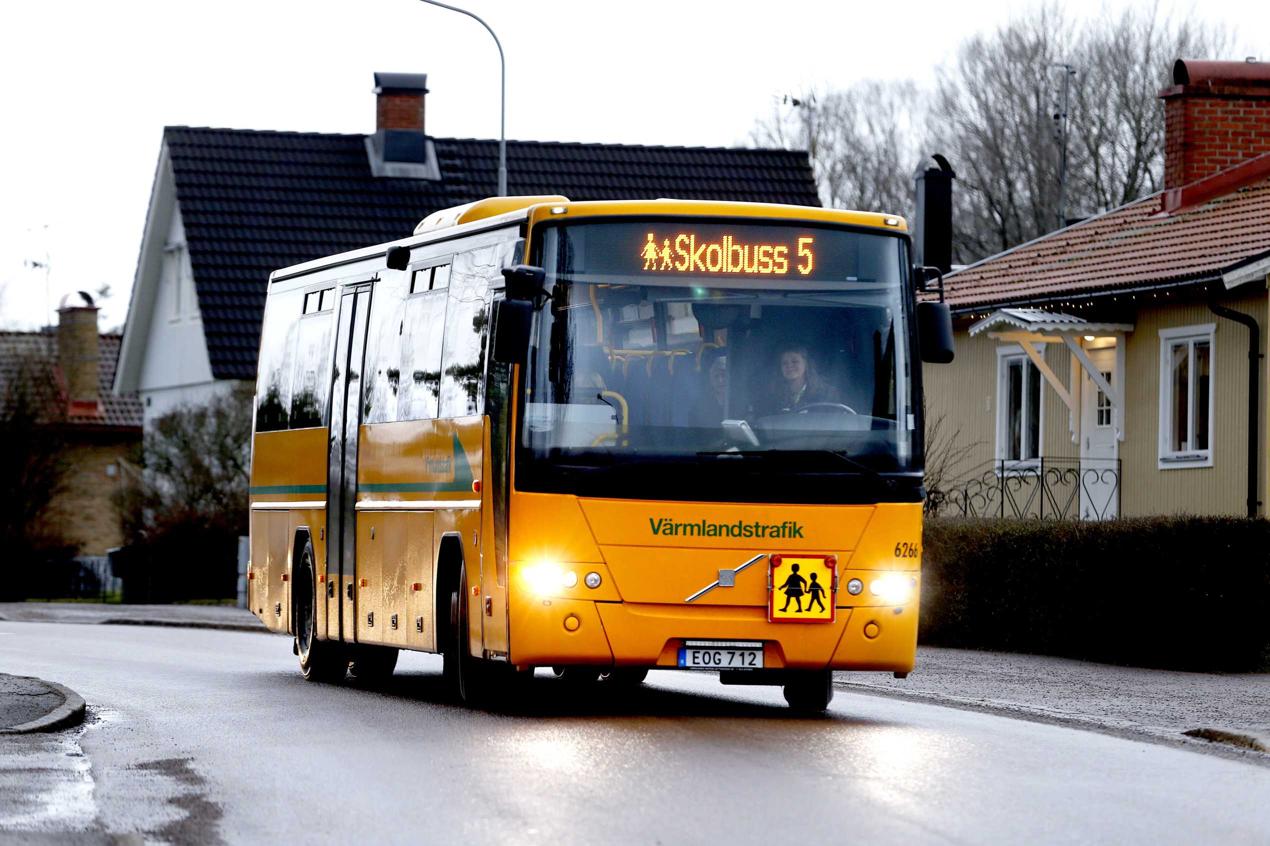 en skolbuss som åker på en bilväg, på bussen står det skolbuss 5